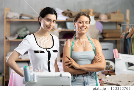 Smiling young professional seamstresses posing in workshop 133353765