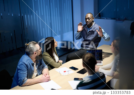 Diverse business team gathered around a table discussing analytics during a meeting in a modern office. Laptop screen shows charts and graphs, symbolizing teamwork, communication, and data driven Diverse business team gathered around a table discussing analytics during a meeting in a modern office. Laptop screen shows charts and graphs, symbolizing teamwork, communication, and data driven 133353783