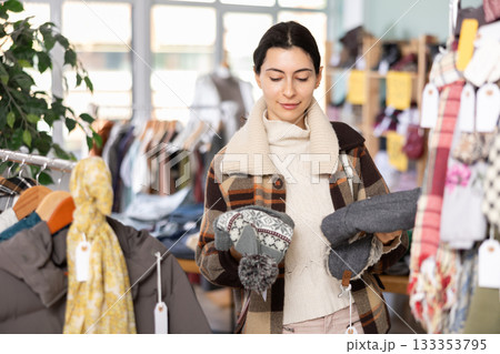 Armenian woman chooses a warm hat for the winter in the store 133353795