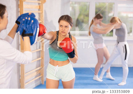 Teen girl in punch mitts boxing 133353809