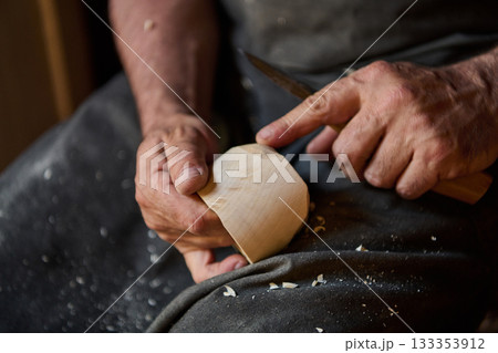 Close up of craftsman hands using knife to carve wood, woodworking process, handmade craft, wood carving, creative hobby, carpentry, DIY project, art, skill, detail shot Close up of craftsman hands using knife to carve wood, woodworking process, handmade craft, wood carving, creative hobby, carpentry, DIY project, art, skill, detail shot 133353912