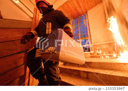 Brave firefighter carrying a rescued cat in a portable cage down smoky stairs during a building fire, symbolizing courage, compassion, and dedication to saving both human and animal lives in Brave firefighter carrying a rescued cat in a portable cage down smoky stairs during a building fire, symbolizing courage, compassion, and dedication to saving both human and animal lives in 133353947