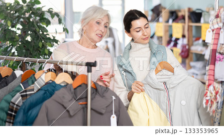 Elderly mother and her adult daughter choose together fashionable handbags in clothing store Elderly mother and her adult daughter choose together fashionable handbags in clothing store 133353965