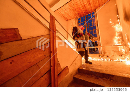 Courageous firefighter carrying a rescued woman down a burning staircase during an emergency evacuation, symbolizing bravery, heroism, and dedication to saving lives in dangerous situations. Courageous firefighter carrying a rescued woman down a burning staircase during an emergency evacuation, symbolizing bravery, heroism, and dedication to saving lives in dangerous situations. 133353966