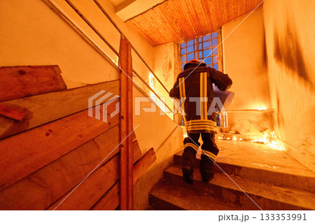 Brave firefighter carrying a rescued cat in a portable cage down smoky stairs during a building fire, symbolizing courage, compassion, and dedication to saving both human and animal lives in Brave firefighter carrying a rescued cat in a portable cage down smoky stairs during a building fire, symbolizing courage, compassion, and dedication to saving both human and animal lives in 133353991