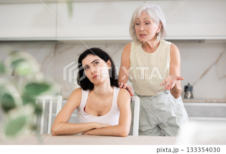 Aggrieved elderly woman having quarrel with her daughter at home. Mature mother expresses claims to adult daughter 133354030