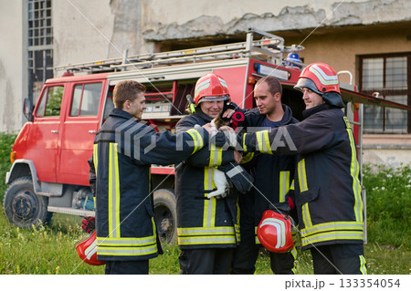 Firefighters rescuing a cat from a fire, team of firemen with a rescued kitten, fire truck in the background, teamwork and compassion, outdoor scene, emergency response Firefighters rescuing a cat from a fire, team of firemen with a rescued kitten, fire truck in the background, teamwork and compassion, outdoor scene, emergency response 133354054