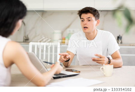 Young guy discussing deal with saleswoman in kitchen Young guy discussing deal with saleswoman in kitchen 133354102