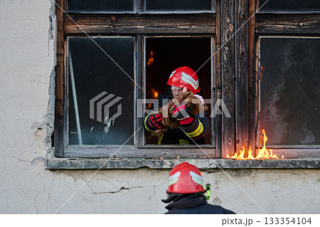 Firefighter rescuing baby from burning building, brave fireman in action, fire safety and emergency response, dramatic scene of hero saving child, outdoor setting Firefighter rescuing baby from burning building, brave fireman in action, fire safety and emergency response, dramatic scene of hero saving child, outdoor setting 133354104