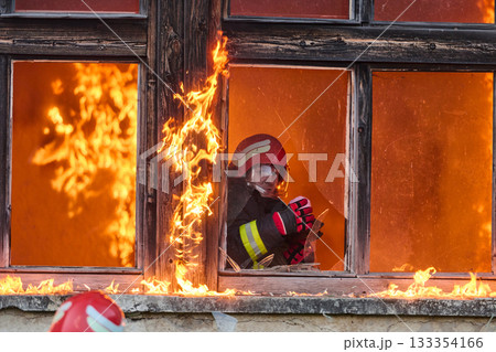 Firefighter rescuing a baby from burning building, fireman in action saving child, emergency situation, fire in house, danger, rescue operation, outdoor scene Firefighter rescuing a baby from burning building, fireman in action saving child, emergency situation, fire in house, danger, rescue operation, outdoor scene 133354166