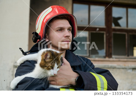 Firefighter rescues cat from burning building, a hero in action, saving a pet, wearing a helmet, outdoor scene, building damage, rescue operation, brave man, animal care 133354173