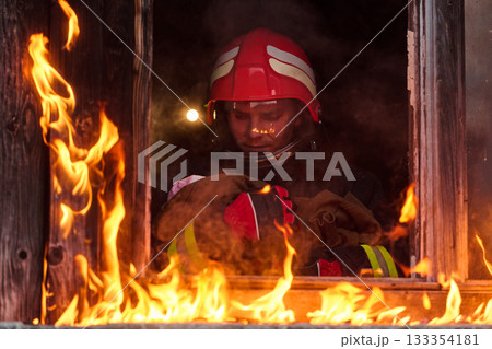 Firefighter rescuing a baby from burning building, fireman in action saving child, emergency situation, fire in house, danger, rescue operation, outdoor scene Firefighter rescuing a baby from burning building, fireman in action saving child, emergency situation, fire in house, danger, rescue operation, outdoor scene 133354181