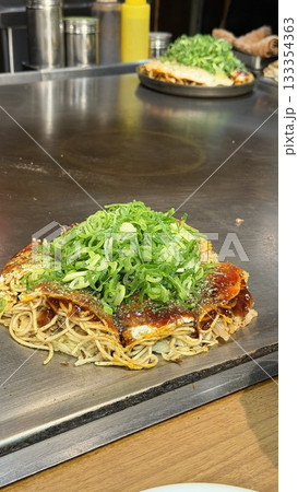 鉄板で焼いたお好み焼きのクローズアップ 鉄板で焼いたお好み焼きのクローズアップ 133354363