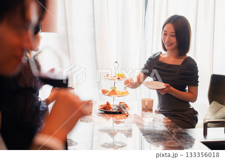 ホテルのアフタヌーンティーで女子会をする若い人々 ホテルのアフタヌーンティーで女子会をする若い人々 133356018