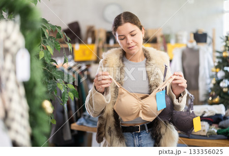 Young girl near showcase pick out and buying ladys bra, New Year eve 133356025