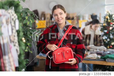 Young woman choosing a handbag in a Christmas shop Young woman choosing a handbag in a Christmas shop 133356026