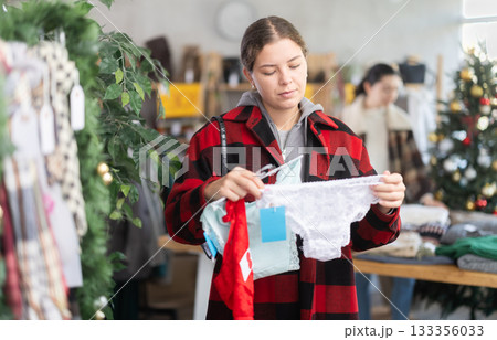 Young girl near showcase pick out and buying ladys panties, New Year eve Young girl near showcase pick out and buying ladys panties, New Year eve 133356033