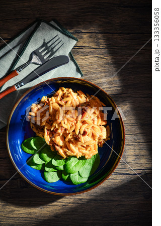 Close-up of Orzo pasta with sun-dried tomato, chicken hard cheese and spinach Close-up of Orzo pasta with sun-dried tomato, chicken hard cheese and spinach 133356058