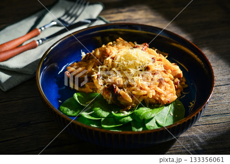 Close-up of Orzo pasta with sun-dried tomato,  chicken hard cheese and spinach 133356061