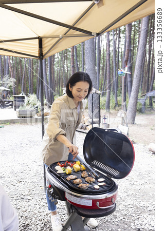 キャンプ場でBBQをする女性 キャンプ場でBBQをする女性 133356689