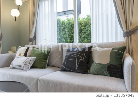 Stylish composition of black and green pillow on living room grey sofa. Modern home decor. Stylish composition of black and green pillow on living room grey sofa. Modern home decor. 133357045