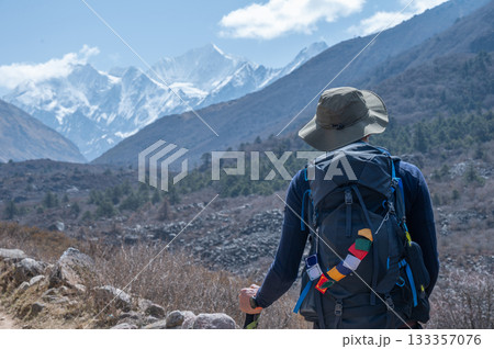 Rear view of tourist looking to beautiful snowcapped mountains while trekking in Langtang national park, Nepal. 133357076