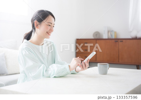 スマホ持つ女性が笑顔で幸せ感じる室内のかわいい日本人 問い合わせやよくある質問 スマホ持つ女性が笑顔で幸せ感じる室内のかわいい日本人 問い合わせやよくある質問 133357596
