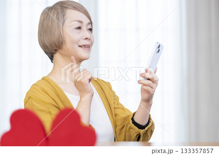 スマホでマッチングアプリをするシニア女性 スマホでマッチングアプリをするシニア女性 133357857