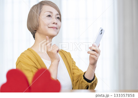 スマホでマッチングアプリをするシニア女性 スマホでマッチングアプリをするシニア女性 133357858