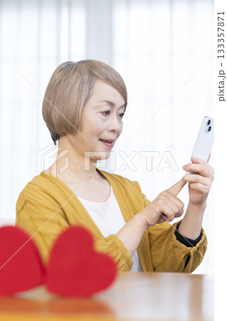 スマホでマッチングアプリをするシニア女性 133357871
