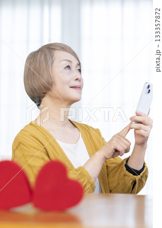 スマホでマッチングアプリをするシニア女性 133357872