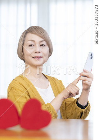 スマホでマッチングアプリをするシニア女性 133357873