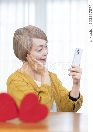 スマホでマッチングアプリをするシニア女性 133357874