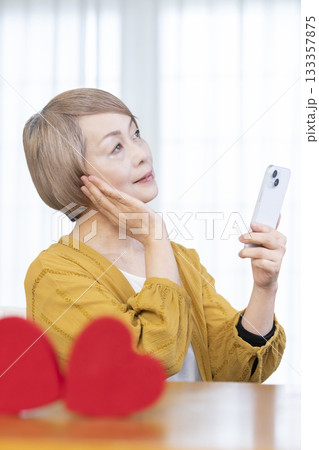 スマホでマッチングアプリをするシニア女性 133357875