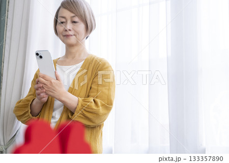 スマホでマッチングアプリをするシニア女性 スマホでマッチングアプリをするシニア女性 133357890