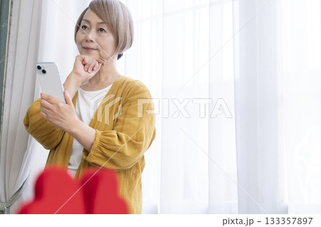スマホでマッチングアプリをするシニア女性 133357897