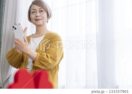 スマホでマッチングアプリをするシニア女性 133357901