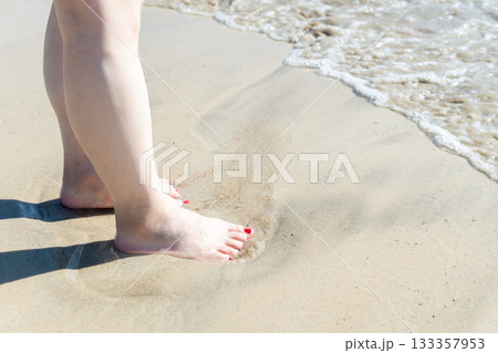 海辺を歩く若い女性　白い波　快晴　シーサイド　素足　美しい　理想　休日　バカンス　ビーチ　女性 133357953