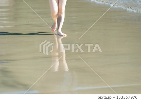 海辺を歩く若い女性　白い波　快晴　シーサイド　素足　美しい　理想　休日　バカンス　ビーチ　女性 133357970