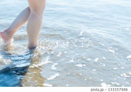 海辺を歩く若い女性　白い波　快晴　シーサイド　素足　美しい　理想　休日　バカンス　ビーチ　女性 133357986