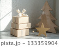 A stack of cardboard boxes beside a wooden Christmas tree and star. AI-generated content. 133359904