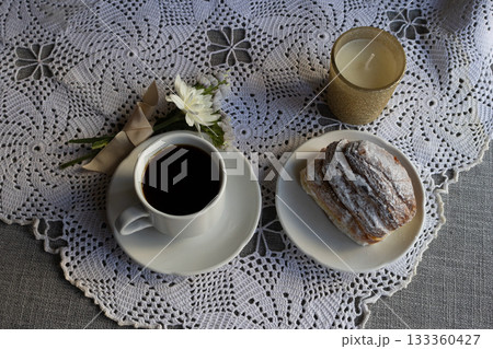 Coffee and brioche served on a romantic tablecloth with a bouquet of white flowers symbolising the celebration. Ideal for Valentine's Day, Mother's Day Coffee and brioche served on a romantic tablecloth with a bouquet of white flowers symbolising the celebration. Ideal for Valentine's Day, Mother's Day 133360427