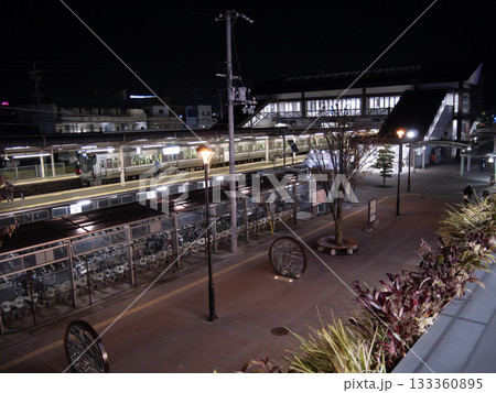 夜の郊外の駅に止まる電車と駅前広場の夜景 133360895