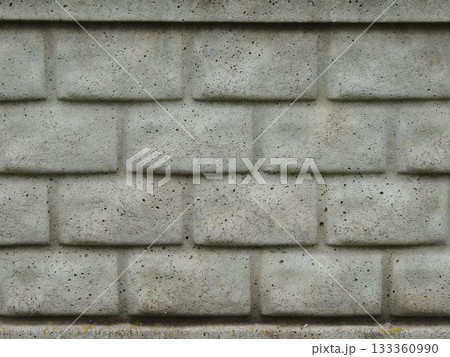 Close-up of a gray concrete wall with foam block texture as a background rough monochromatic convex abstraction, a fragment of a fence or building facade made of blocks as a textured empty backdrop 133360990