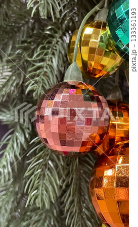 Vibrant, colorful disco ball Christmas ornaments reflecting light on a festive branch 133361193