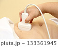 Modern ultrasound device. Ultrasound examination of internal organs. A woman undergoing an ultrasound scan of her abdominal cavity. Ultrasound examination device. Modern ultrasound device. Ultrasound examination of internal organs. A woman undergoing an ultrasound scan of her abdominal cavity. Ultrasound examination device. 133361945