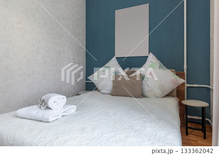 Cozy Bed with White Linen and Blue Accent Wall 133362042