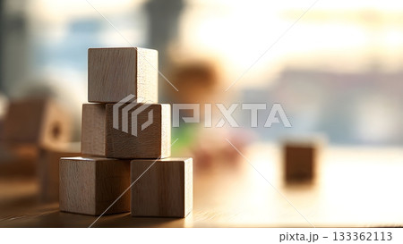 Close-up focus on a stack of simple wooden cubes on a table, symbolizing early education, construction, and childhood development with a child blurred in the background. AI Generated 133362113