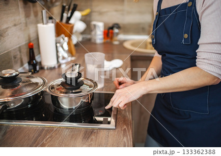 Cooking a delicious meal while preparing in a cozy kitchen atmosphere 133362388