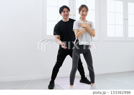 パーソナルトレーナーにトレーニングを受ける若い女性 133362996